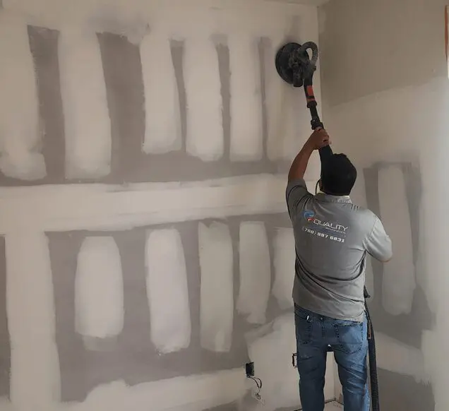 A man is working on the wall of his home.